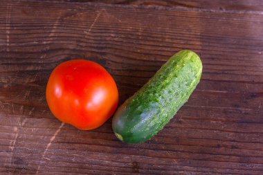 Taze, olgun domates ve salatalık görünümünü geri ahşap üzerine kapatın
