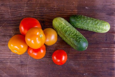 Taze, olgun domates ve salatalık görünümünü geri ahşap üzerine kapatın