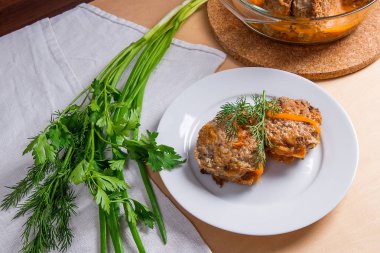 Beyaz bir tabak ve otlar - dereotu, yeşil servis domuz eti köfte 