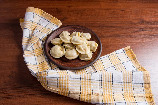 Gekookte Oekraïense vlees knoedels of ravioli op houten achtergrond. — Stockfoto