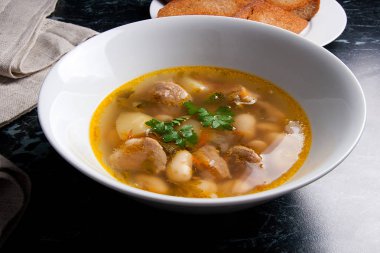 Beyaz plaka, beyaz bir blac tabağa birkaç tost fasulye çorbası