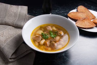 Beyaz plaka, beyaz bir blac tabağa birkaç tost fasulye çorbası