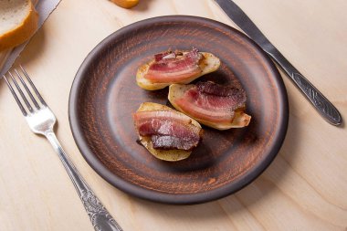 Ahşap zemin üzerine pastırma dilimlerini fırında patates. Dilimleri