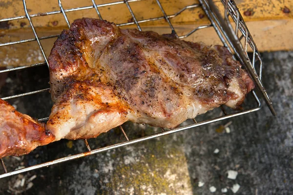 Close up view of juicy pork steak cooked on an open flame grill.