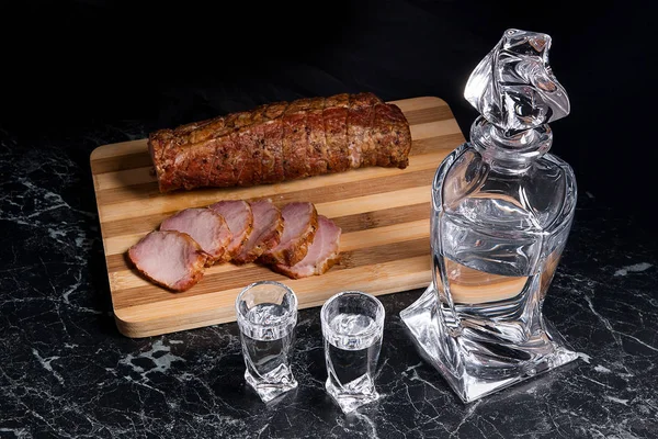 Fles en shot glazen met wodka met plakjes gerookte vlees op — Stockfoto