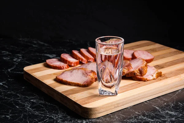 Shot glazen met wodka, plakjes gerookt vlees en gerookte sausag — Stockfoto