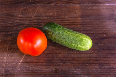 Taze, olgun domates ve salatalık görünümünü geri ahşap üzerine kapatın