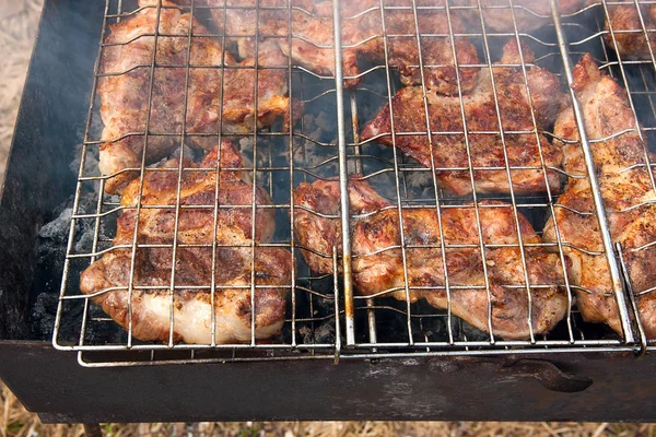 Carne de cerdo jugosa cocinándose en una parrilla de llama abierta . — Foto de Stock