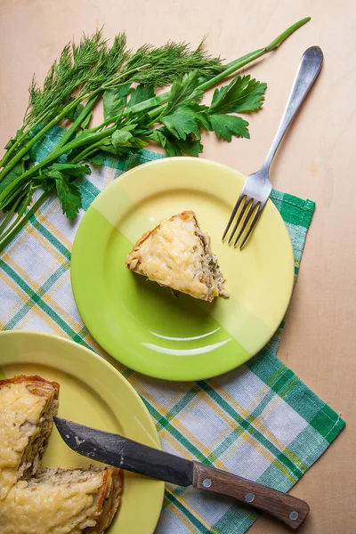 Piece of pancakes pie with mushrooms and chicken meat on green p — Stock Photo, Image