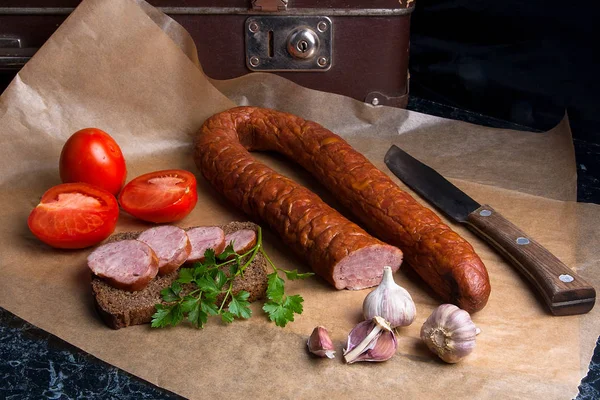 Slices of smoked sausage with spice, herbs and vegetables on the
