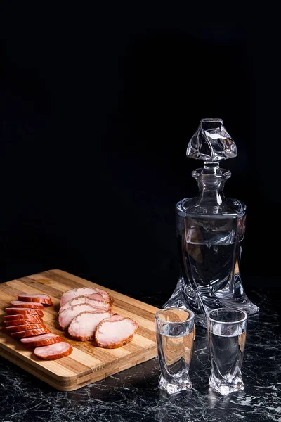 Fles en shot glazen met wodka, plakjes gerookt vlees en sm — Stockfoto
