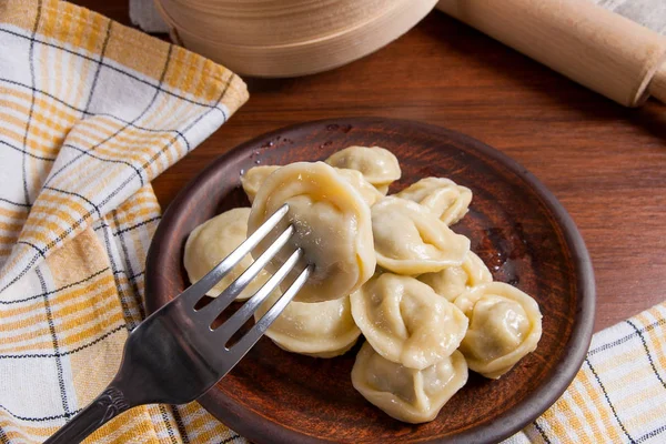 Close up view of boiled meat dumpling on metal fork. Served in c — Stock Photo, Image
