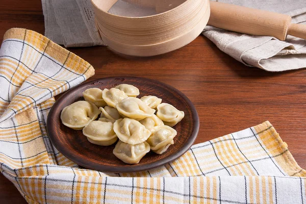 Gekookte Oekraïense vlees knoedels of ravioli op houten achtergrond. — Stockfoto