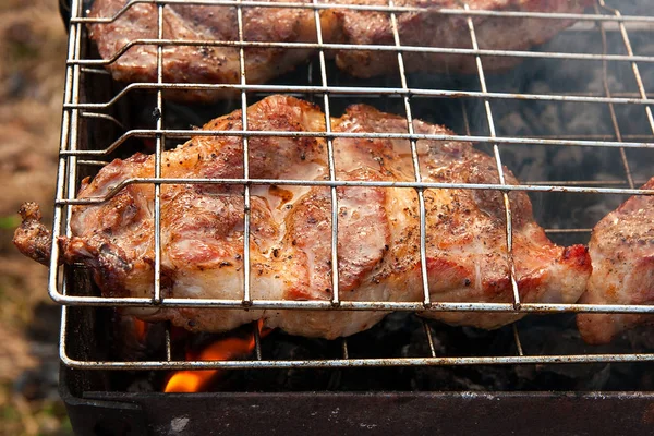 Vista da vicino della succosa cottura della bistecca di maiale su una griglia a fiamma aperta — Foto Stock