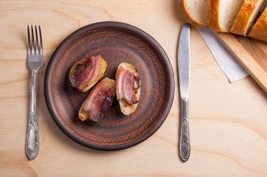 Ahşap zemin üzerine pastırma dilimlerini fırında patates. Dilimleri