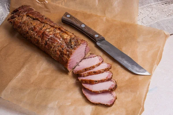 Szeletelt füstölt húst vagy a sonka és a kést a barna csomagoló papír. — Stock Fotó