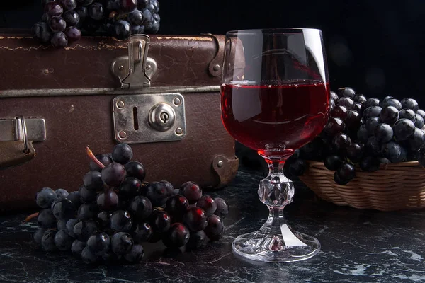 暗い大理石の背景に赤ワインのガラス。青い gra のクラスター — ストック写真