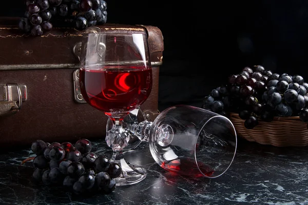 暗い大理石の背景に赤ワインのガラス。青い gra のクラスター — ストック写真