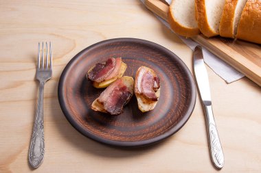 Ahşap zemin üzerine pastırma dilimlerini fırında patates. Dilimleri