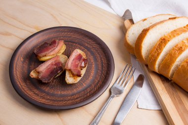 Ahşap zemin üzerine pastırma dilimlerini fırında patates. Dilimleri