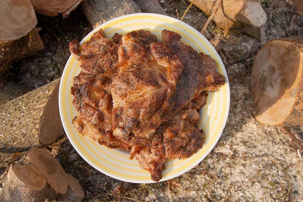 Bifes de porco suculentos cozidos em uma grelha de chama aberta no pla branco grande — Fotografia de Stock