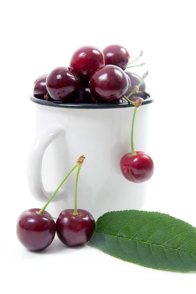 Bílý hrnek s červeným sweet cherry izolovaných na bílém pozadí — Stock fotografie