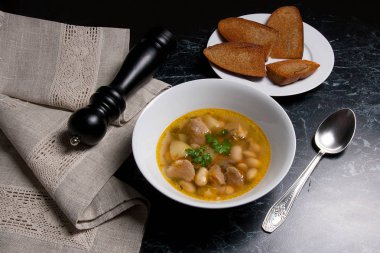 Metal kaşık, whit birkaç tost ile beyaz tabak fasulye çorbası