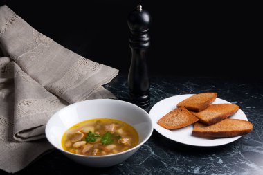 Beyaz plaka, beyaz bir blac tabağa birkaç tost fasulye çorbası