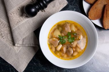 Beyaz plaka, beyaz bir blac tabağa birkaç tost fasulye çorbası