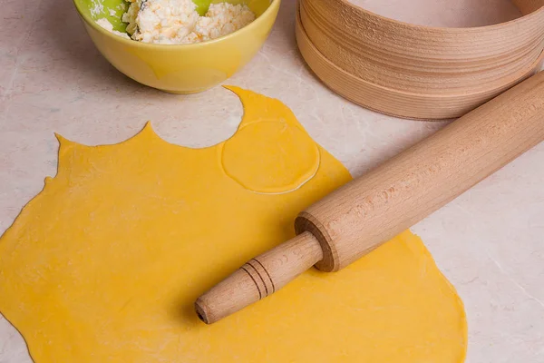 Rolling pin, sieve and rolled out dough and green bowl with cott — Stock Photo, Image