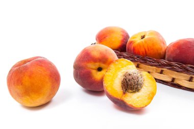 Bütün ve olgun şeftali meyve yarısı ve sepet izole içinde birkaç