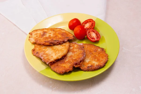 İle et ve domates Belarus yeşil plaka üzerinde patates pancakes