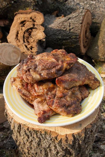 Succose bistecche di maiale cotte su una griglia a fiamma aperta su una grande pla bianca — Foto Stock