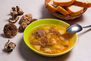 Metal kaşık, kurutulmuş vahşi mushro ile yeşil plaka mantar çorbası