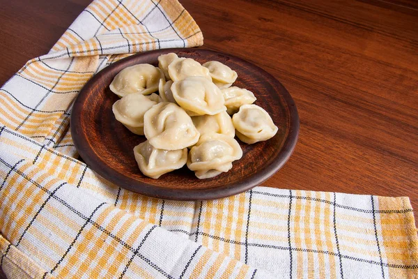 Boiled Ukrainian meat dumplings or ravioli on wooden background. — Stock Photo, Image