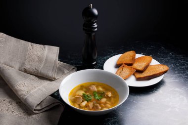 Beyaz plaka, beyaz bir blac tabağa birkaç tost fasulye çorbası