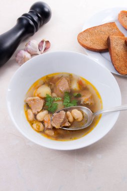 Metal kaşık, whit birkaç tost ile beyaz tabak fasulye çorbası