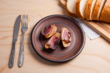 Ahşap zemin üzerine pastırma dilimlerini fırında patates. Dilimleri