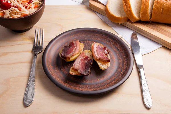 Dilim pastırma ve mutfak eşyaları woode üzerinde yemek fırında patates