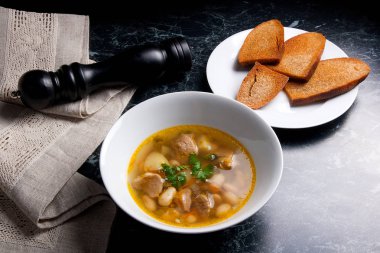 Beyaz plaka, beyaz bir blac tabağa birkaç tost fasulye çorbası