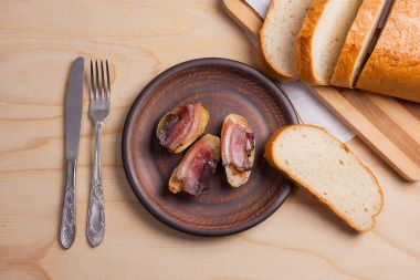 Ahşap zemin üzerine pastırma dilimlerini fırında patates. Dilimleri