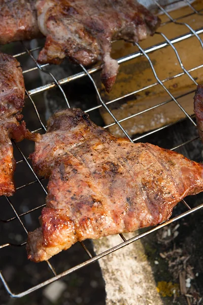 Vue rapprochée du steak de porc juteux cuit sur un gril à flamme nue . — Photo