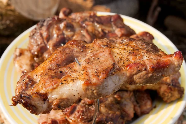 Vista da vicino della succosa bistecca di maiale sulla forchetta cotta a fiamma aperta — Foto Stock