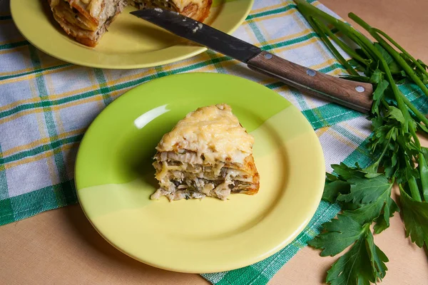 Piece of pancakes pie with mushrooms and chicken meat on green p — Stock Photo, Image