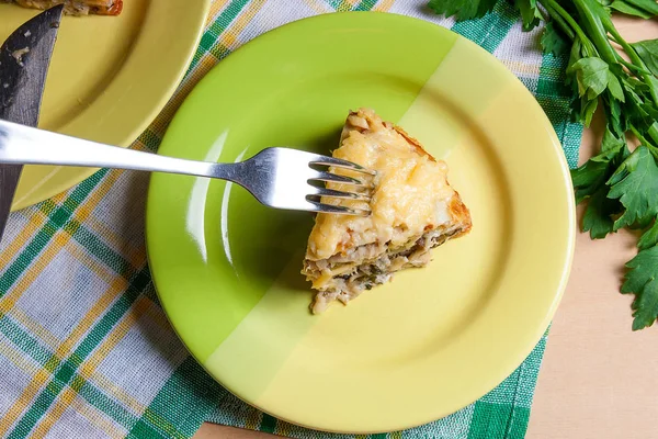 Piece of pancakes pie with mushrooms and chicken meat on green p — Stock Photo, Image