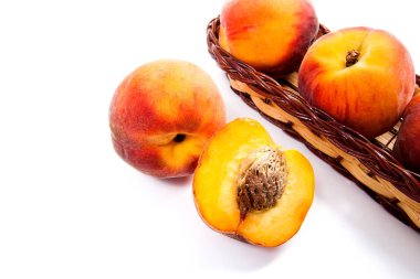 Bütün ve olgun şeftali meyve yarısı ve sepet izole içinde birkaç
