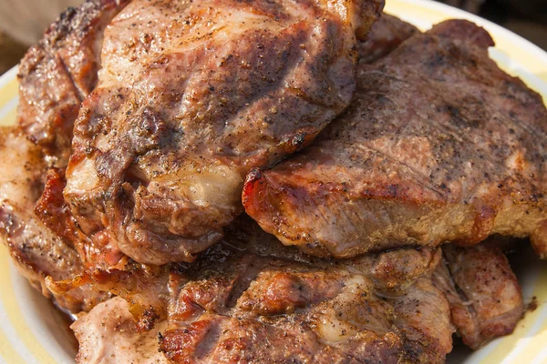 Крупный план сочного свиного стейка, приготовленного на открытом гриле — стоковое фото