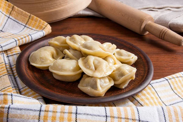 Gekookte Oekraïense vlees knoedels of ravioli op houten achtergrond. — Stockfoto