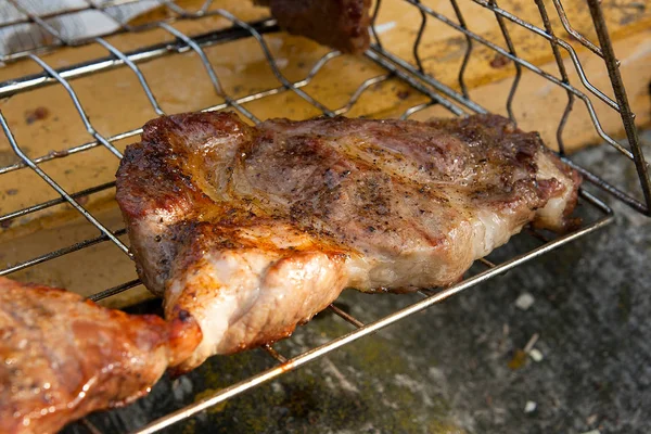 Vue rapprochée du steak de porc juteux cuit sur un gril à flamme nue . — Photo