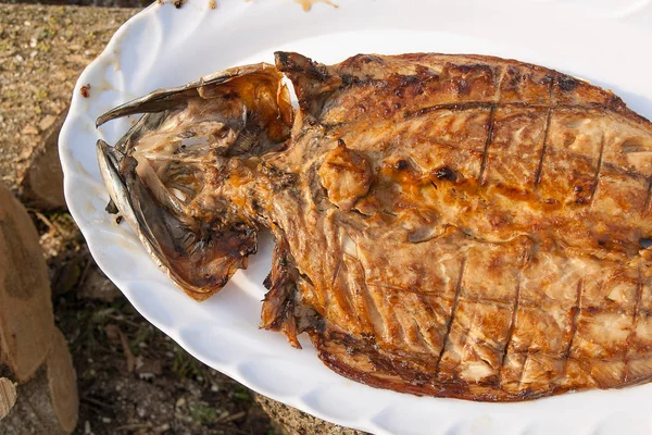 Close up view of fresh fish with sauce cooked on an open flame g